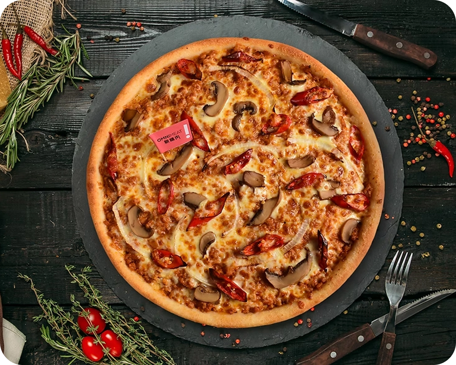 Flatlay Pizza on dark wooden table with herbs and cutlery